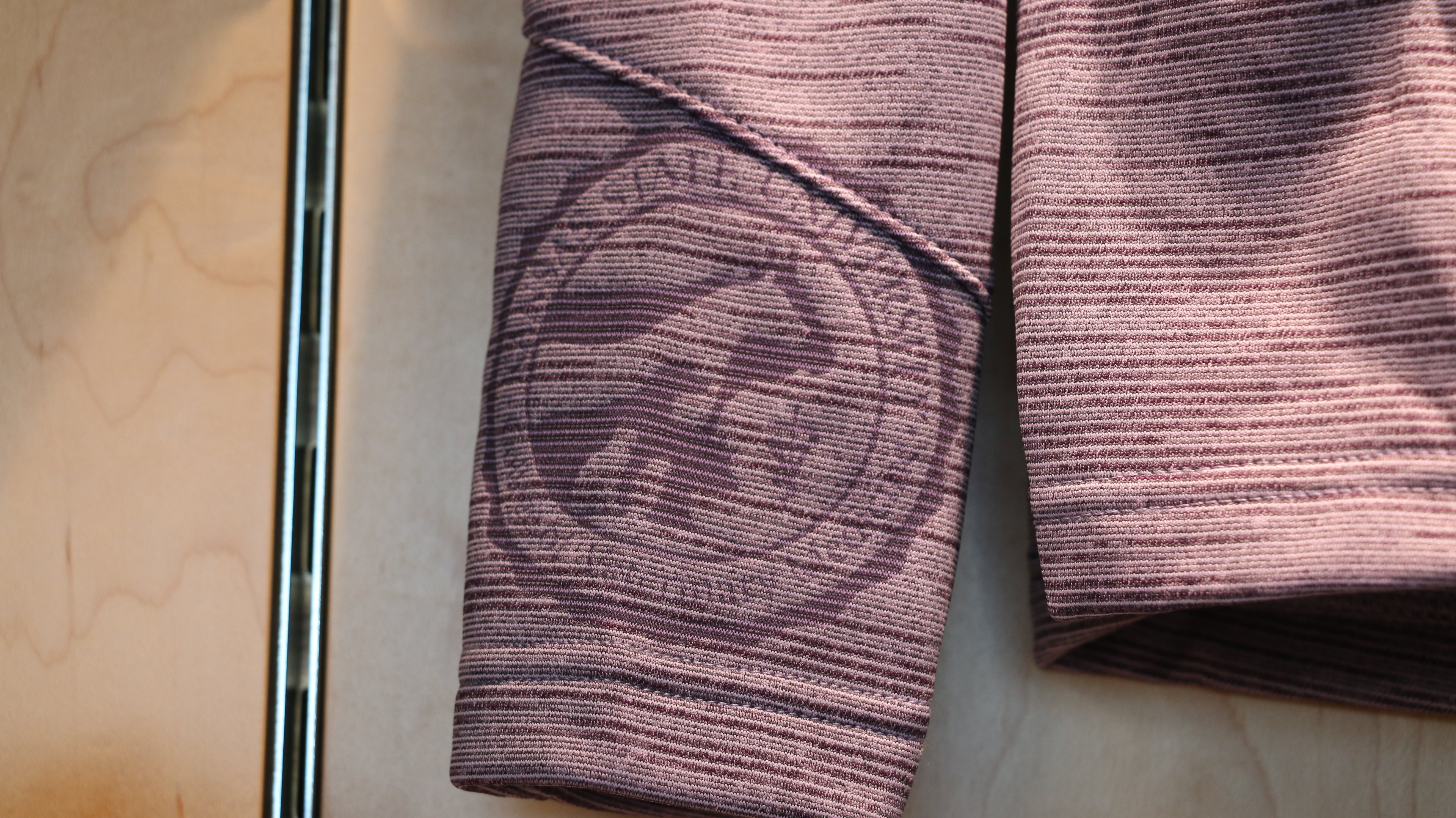 A close-up view of the laser etched college seal on the right cuff.