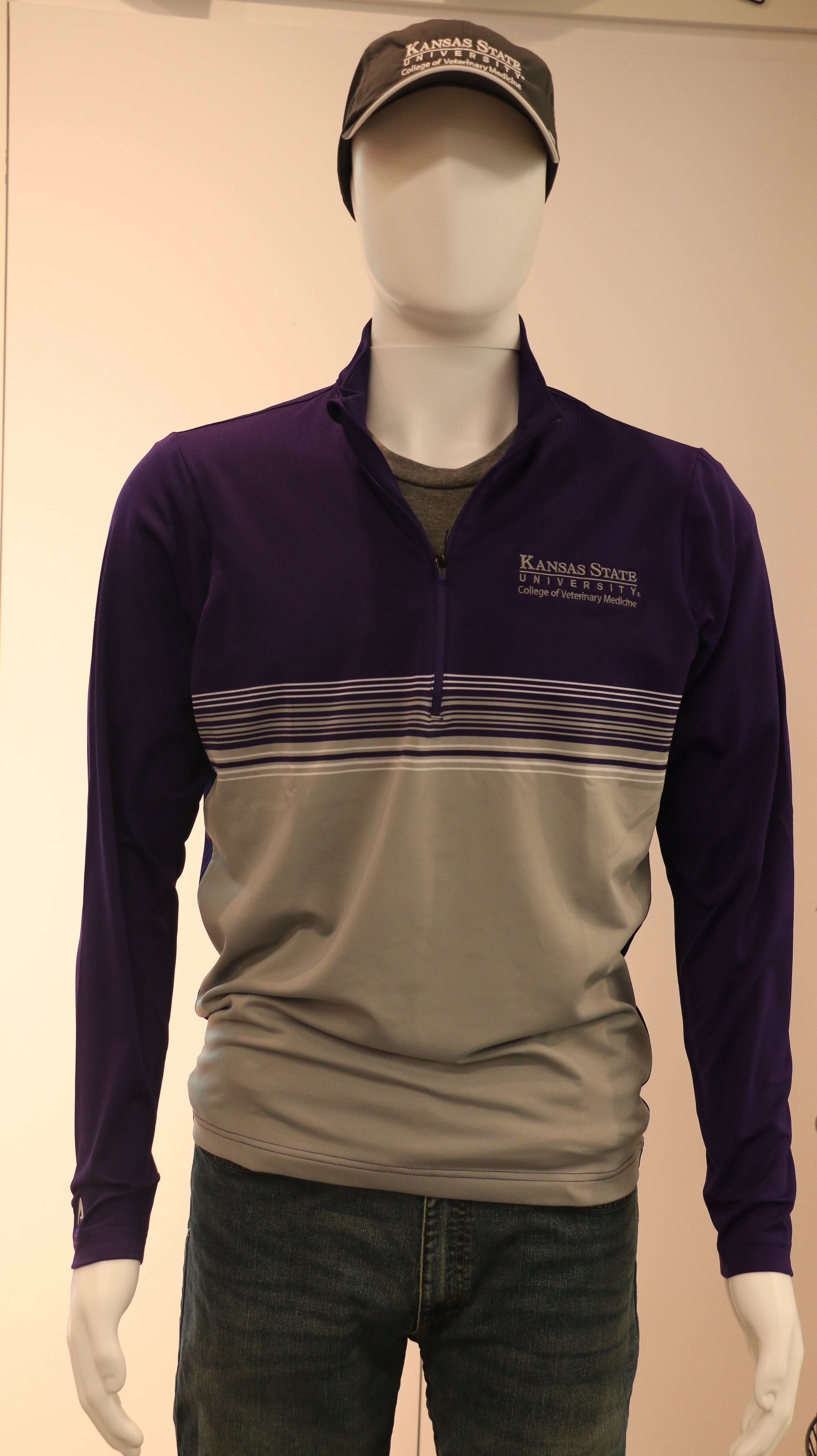 A mannequin wearing a customized Men's Antigua Pace 1/4 Zip Pullover in purple and gray colors with a white K-State CVM logo on the chest.