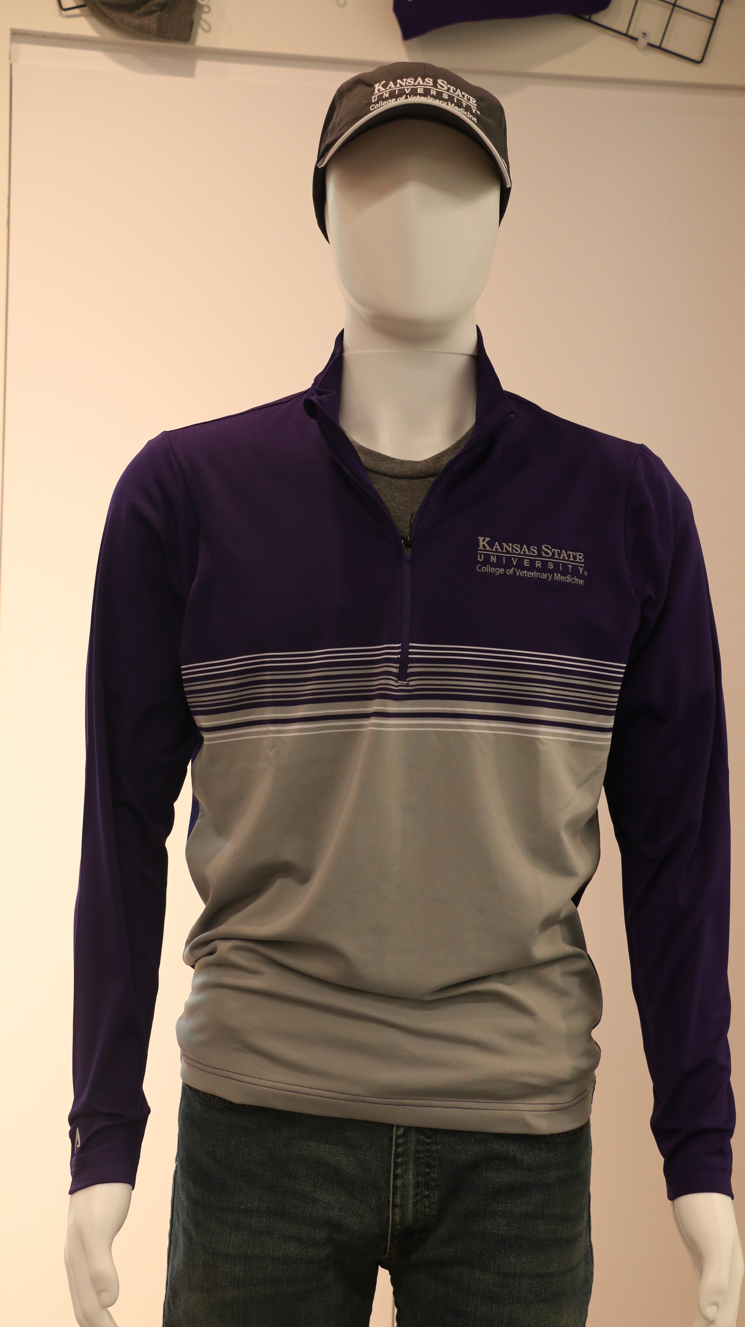 A mannequin wearing a customized Men's Antigua Pace 1/4 Zip Pullover in purple and gray colors with a white K-State CVM logo on the chest.