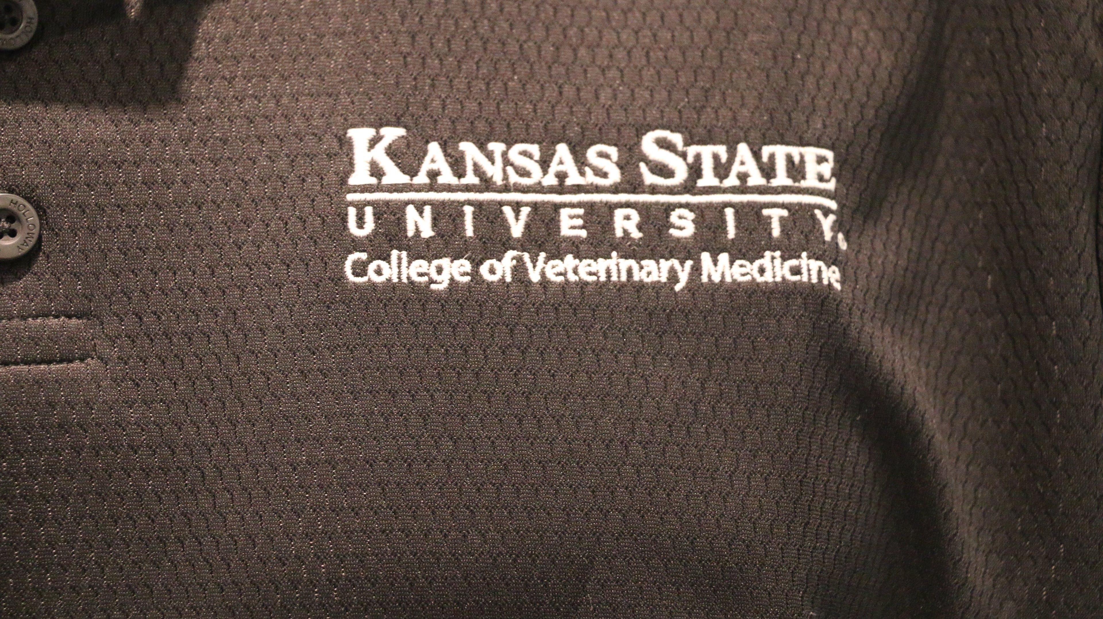 A close-up view of the white CVM logo on the upper left chest area. 
