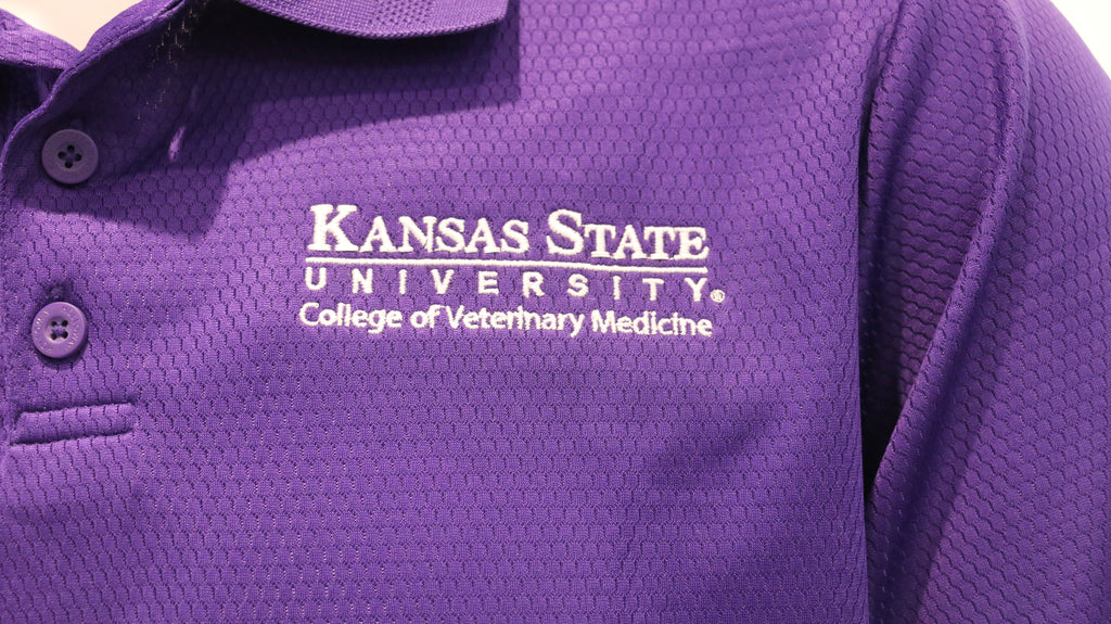 A close-up view of the white CVM logo on the upper left chest area. 