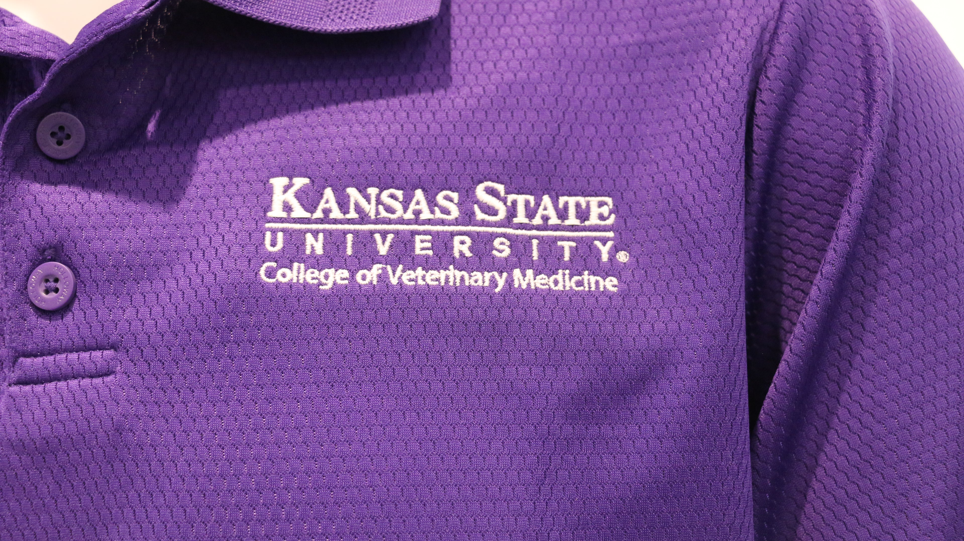 A close-up view of the white CVM logo on the upper left chest area. 