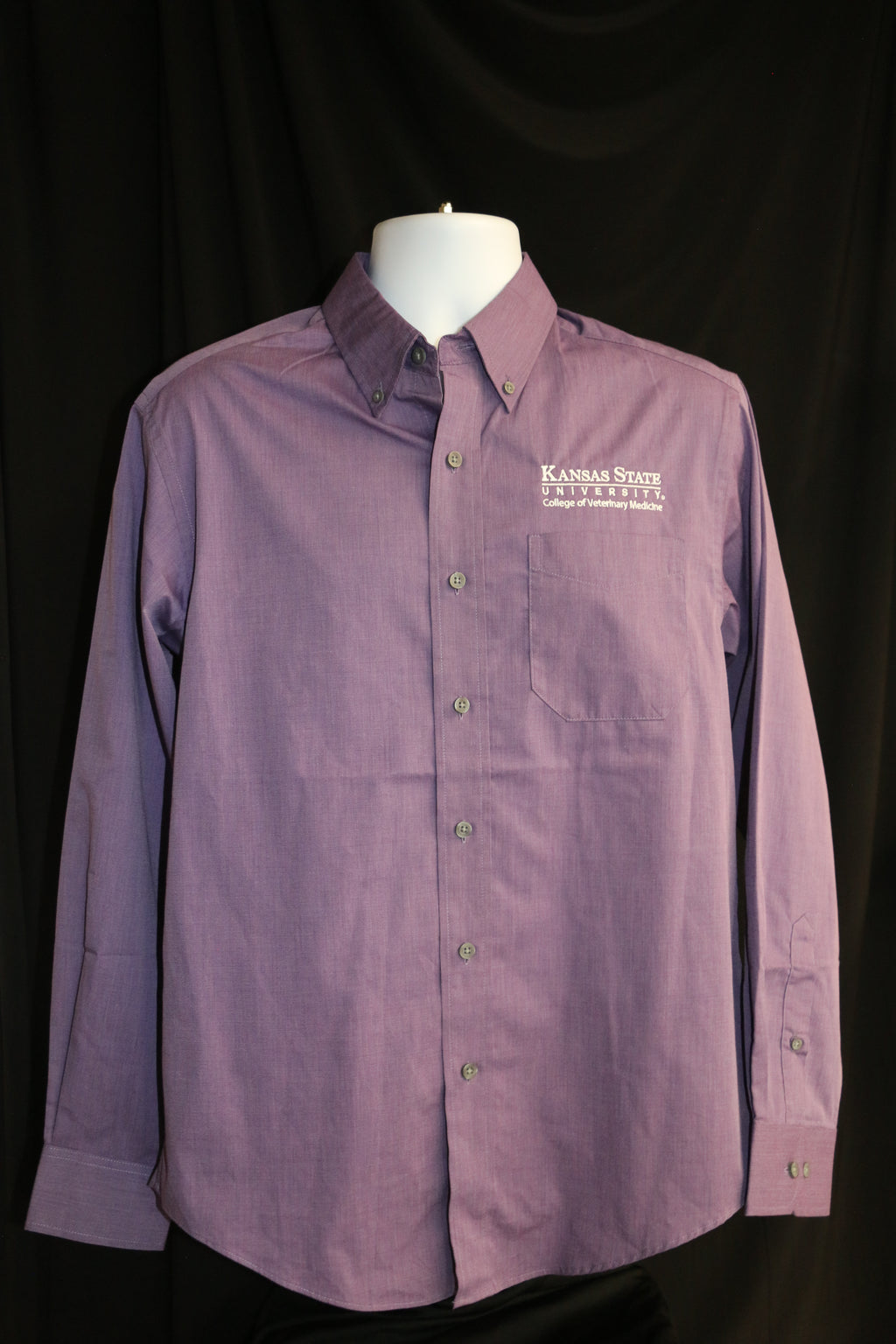 A customized Port Authority Purple Woven long sleeve dress shirt with a white K-State logo on the upper left side above a chest pocket. 