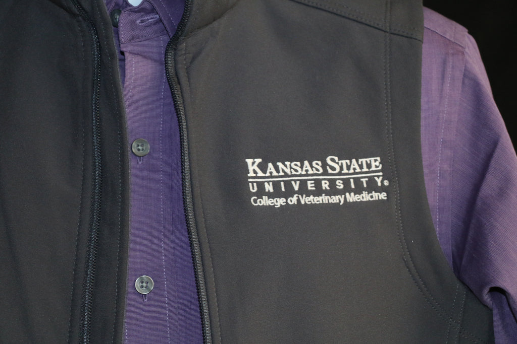 A close-up view of the white CVM logo on the upper left side of the vest. 