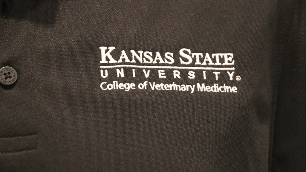 A close-up view of the white CVM logo on the upper left chest area. 