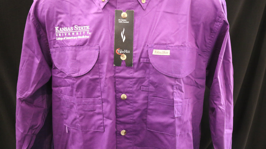 A Men's Tiger Hill Fishing Shirt Long Sleeve button down in the color purple with pockets on the chest and a white embroidered CVM logo. 