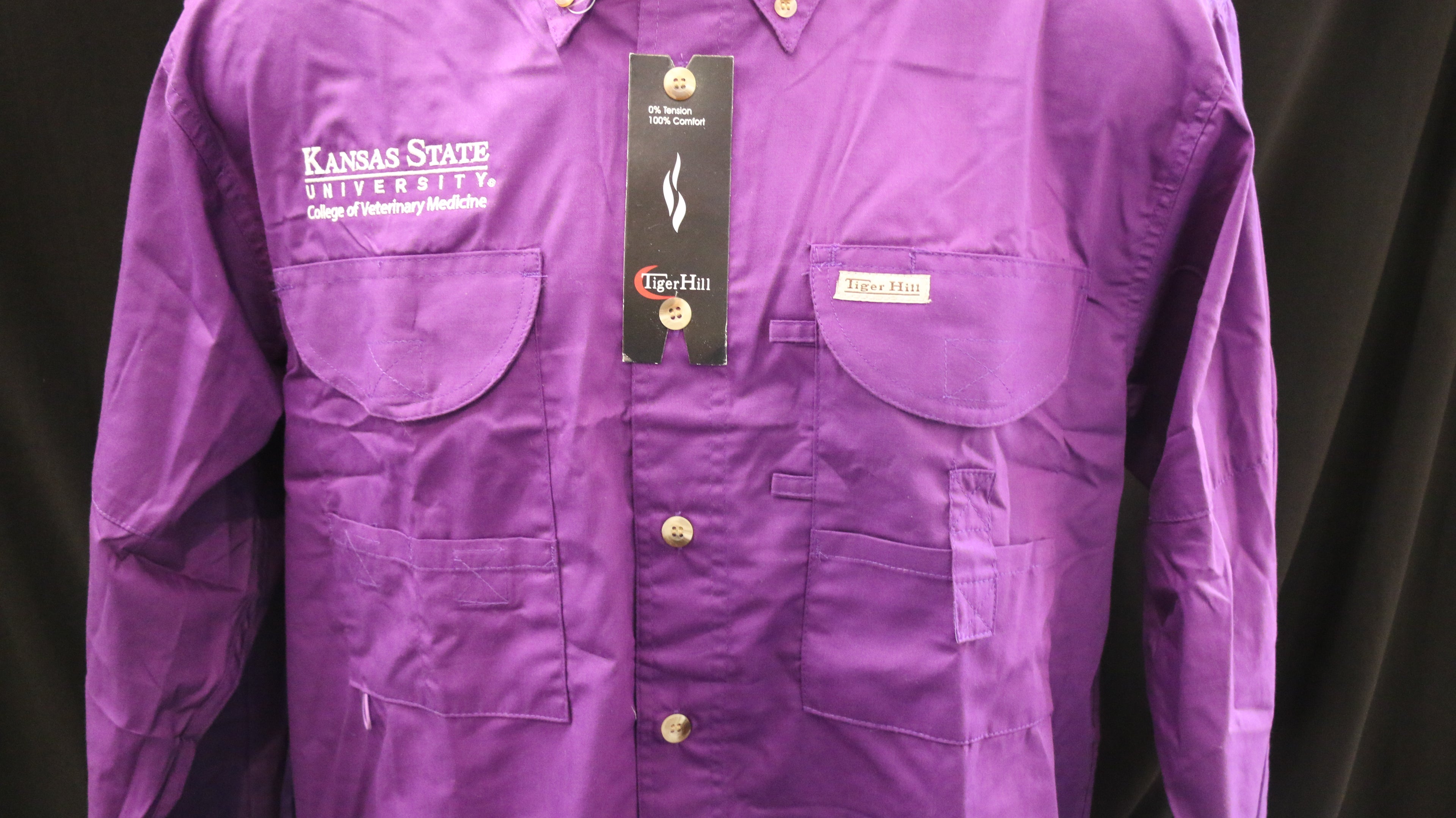 A Men's Tiger Hill Fishing Shirt Long Sleeve button down in the color purple with pockets on the chest and a white embroidered CVM logo. 