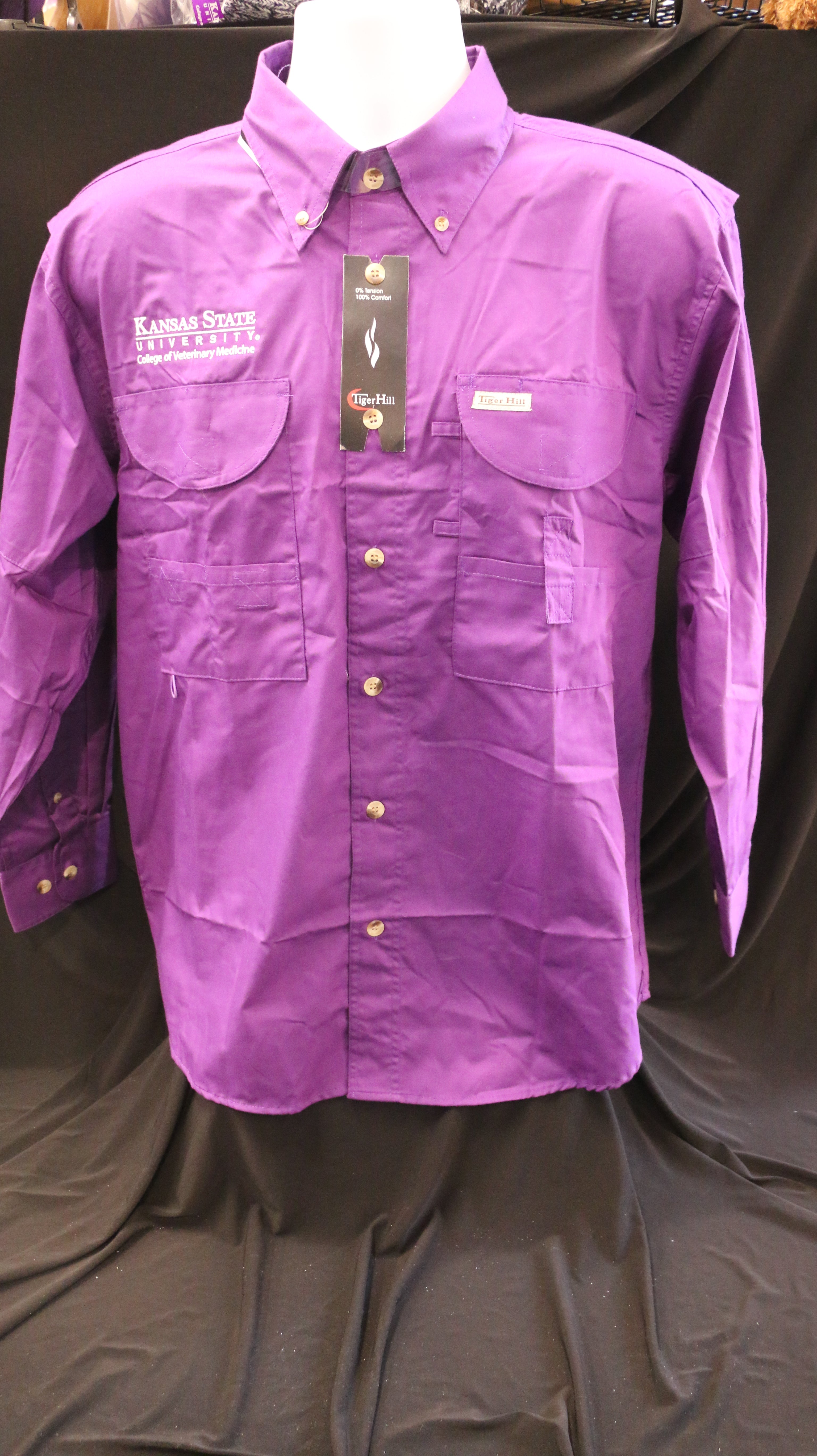 A Men's Tiger Hill Fishing Shirt Long Sleeve button down in the color purple with pockets on the chest and a white embroidered CVM logo. 