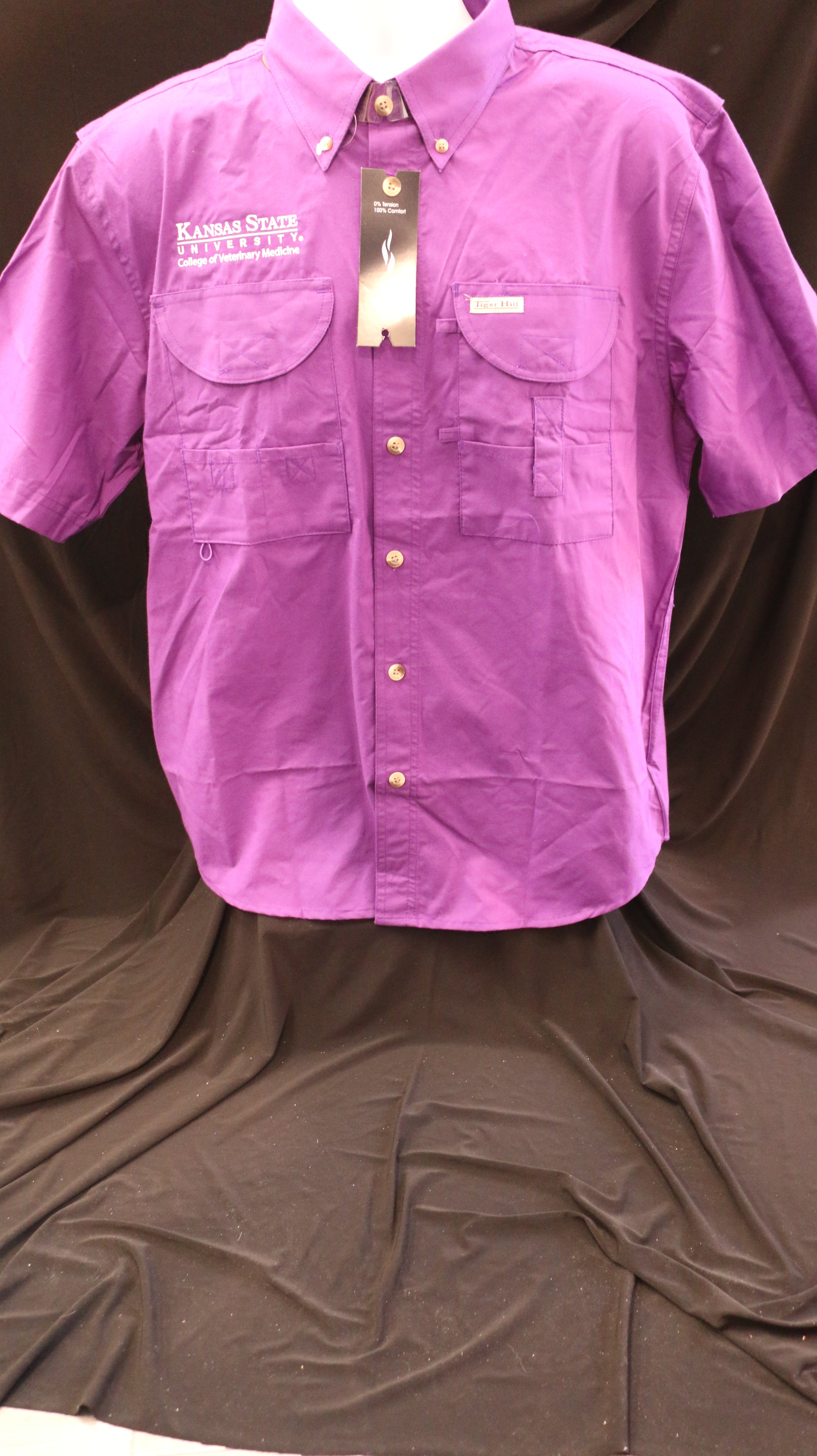 A short-sleeved purple Tiger Hill fishing button down shirt with a white embroidered CVM logo, displayed on a mannequin against a black background.