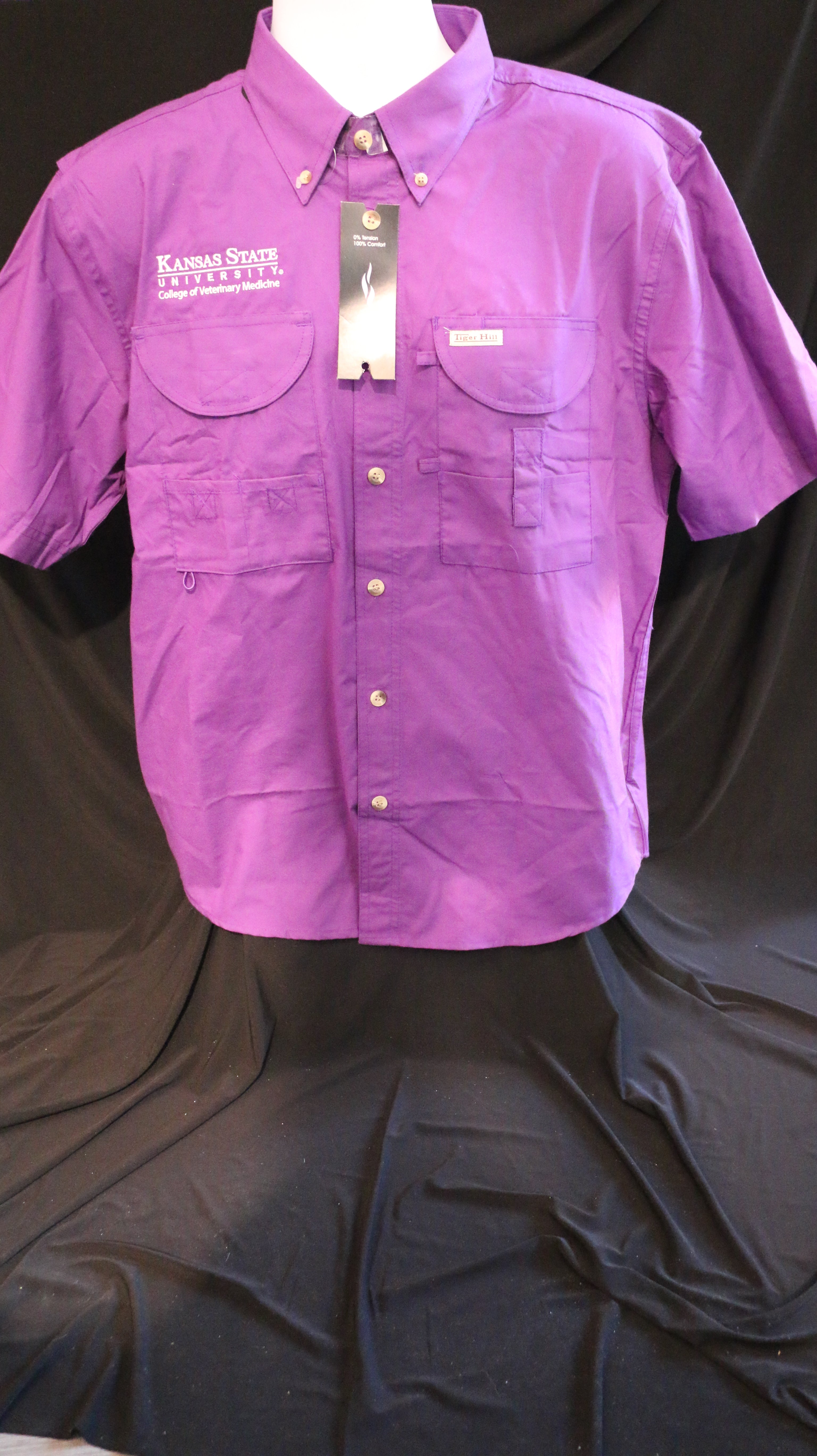 A short-sleeved purple Tiger Hill fishing button down shirt with a white embroidered CVM logo, displayed on a mannequin against a black background.
