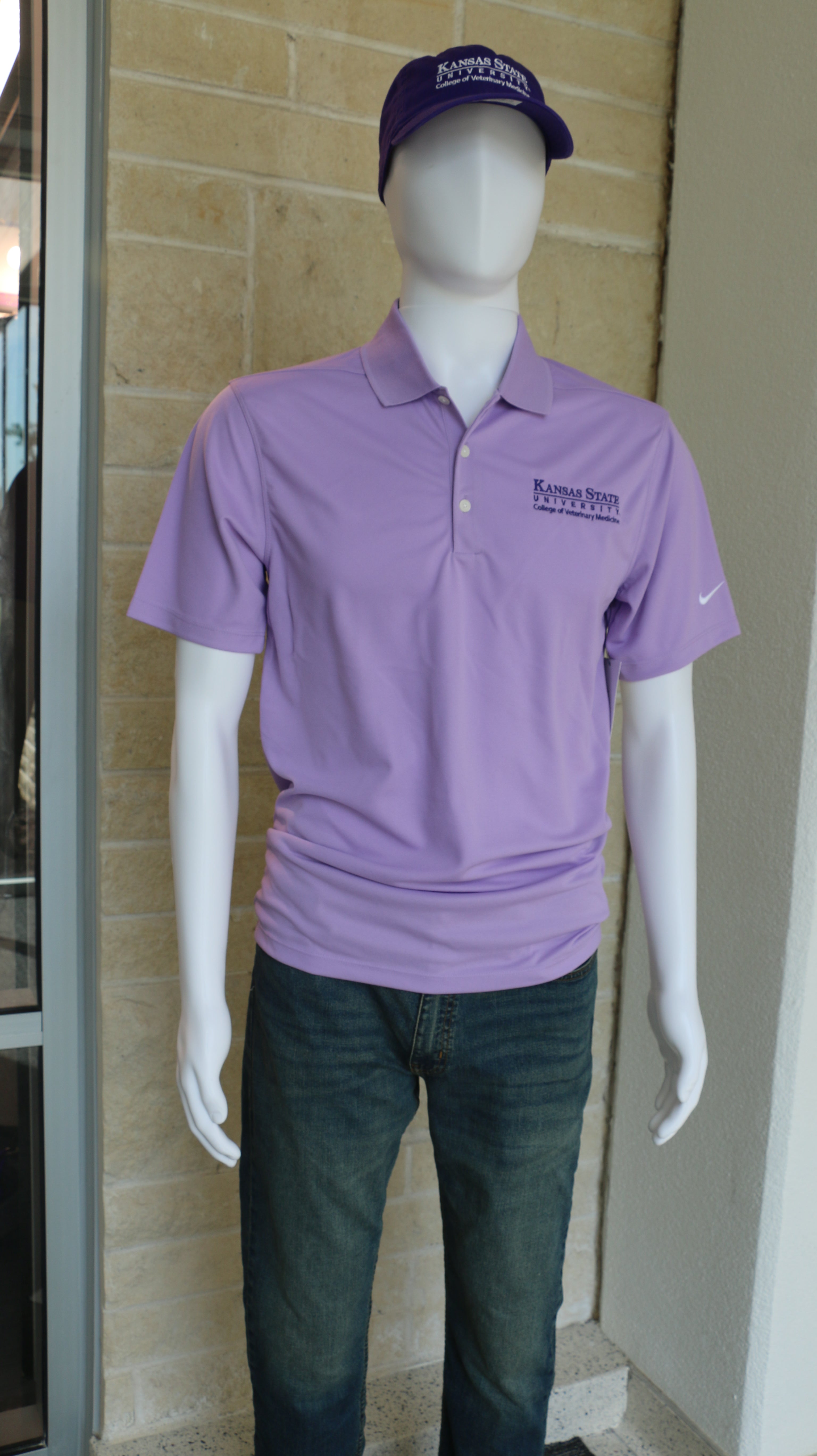 A mannequin wearing a custom Nike Dri-Fit polo shirt in Urban Lilac color and dark purple K-State CVM lettering.