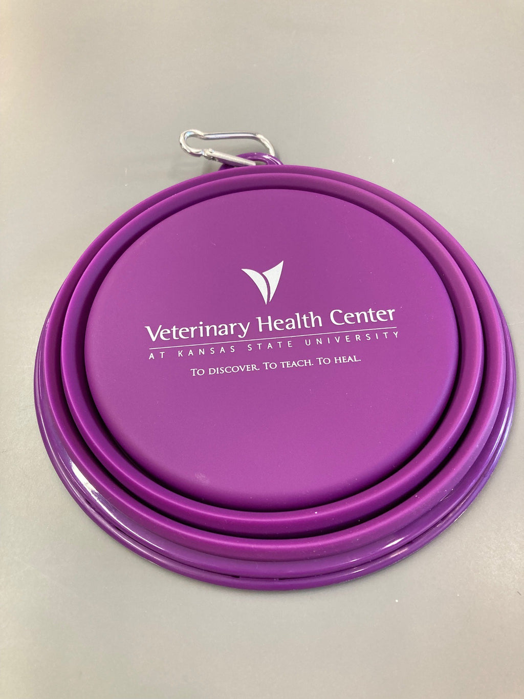 A 32oz purple collapsible silicone pet bowl displayed open and empty with a white Veterinary Health Center logo in the center. 