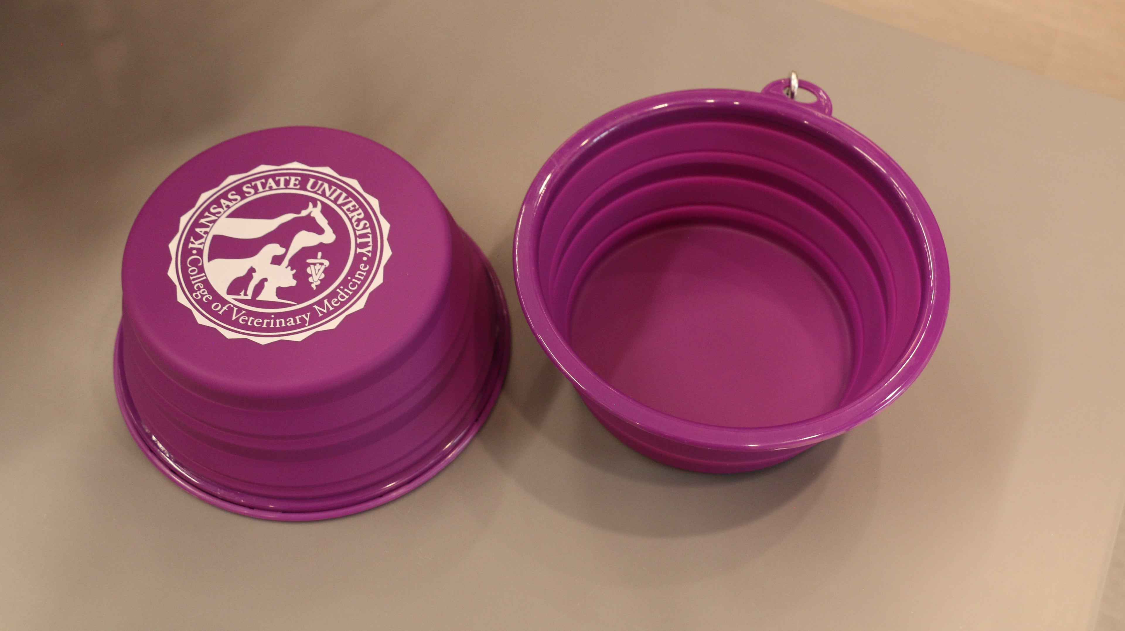 A 32oz purple collapsible silicone pet bowl displayed open and empty with a white College of Veterinary Medicine logo in the center. 