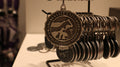 A pewter Christmas ornament with a university logo and the year 2021 inscribed on it, displayed on a chain.
