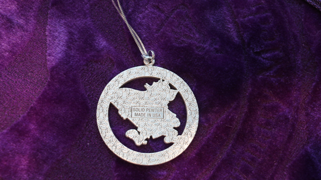 The back of the ornament which reads "Solid Pewter Made in USA" in small writing. 