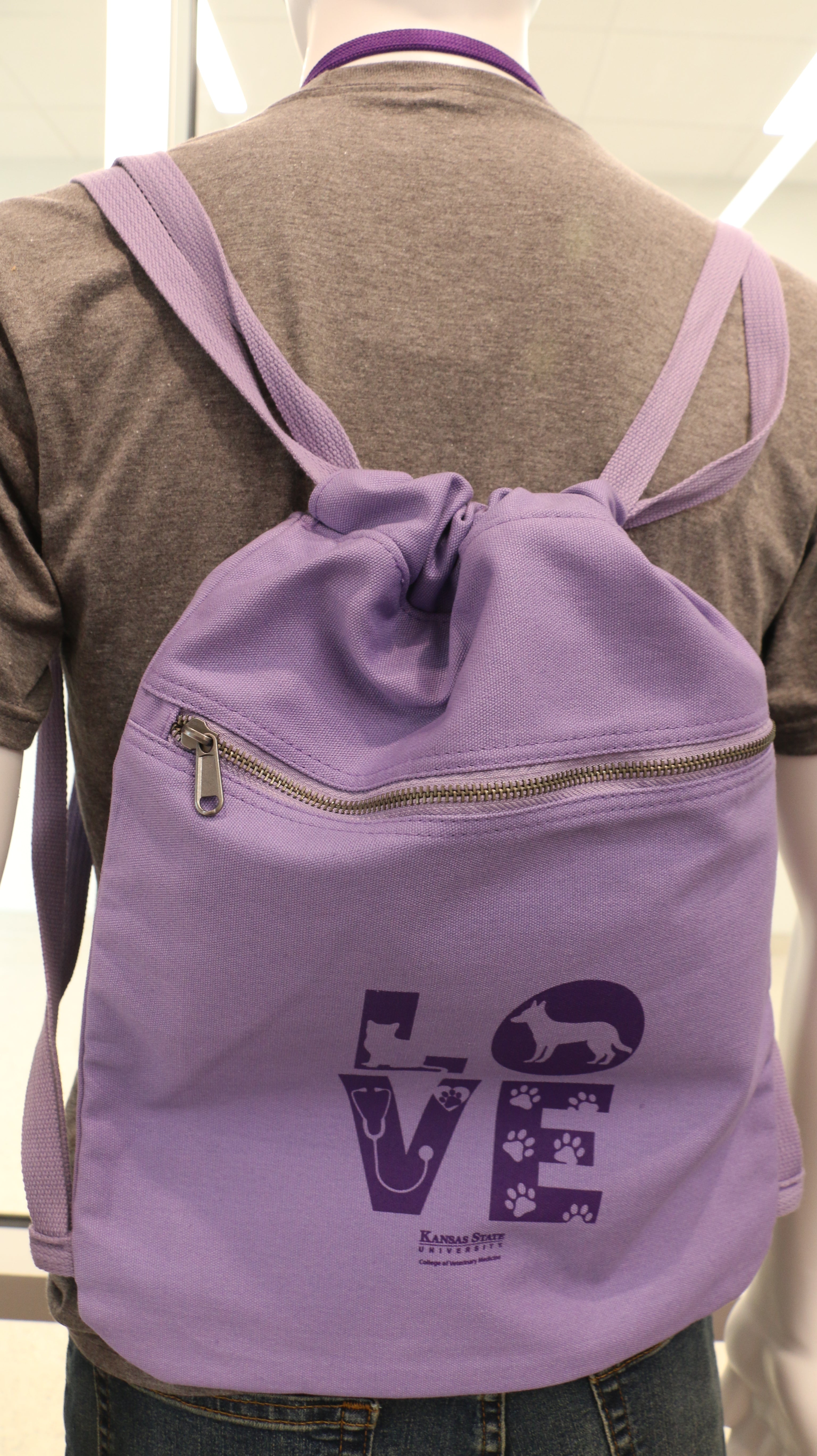 A purple Port Authority Beach Wash Cinch Pack on a mannequin's back, featuring a graphic with the word 'love'.