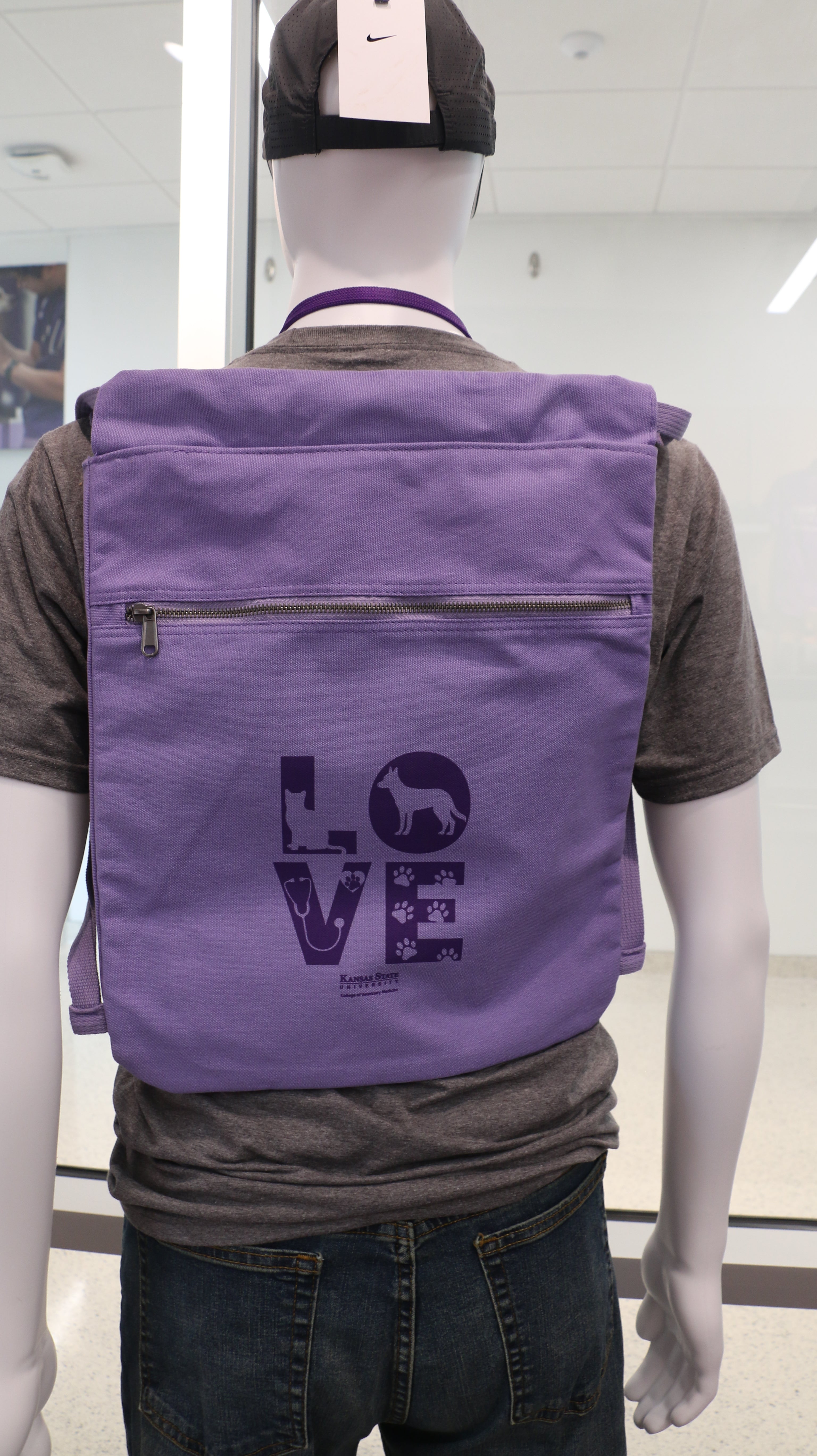 A purple Port Authority Beach Wash Cinch Pack on a mannequin's back, featuring a graphic with the word 'love'.
