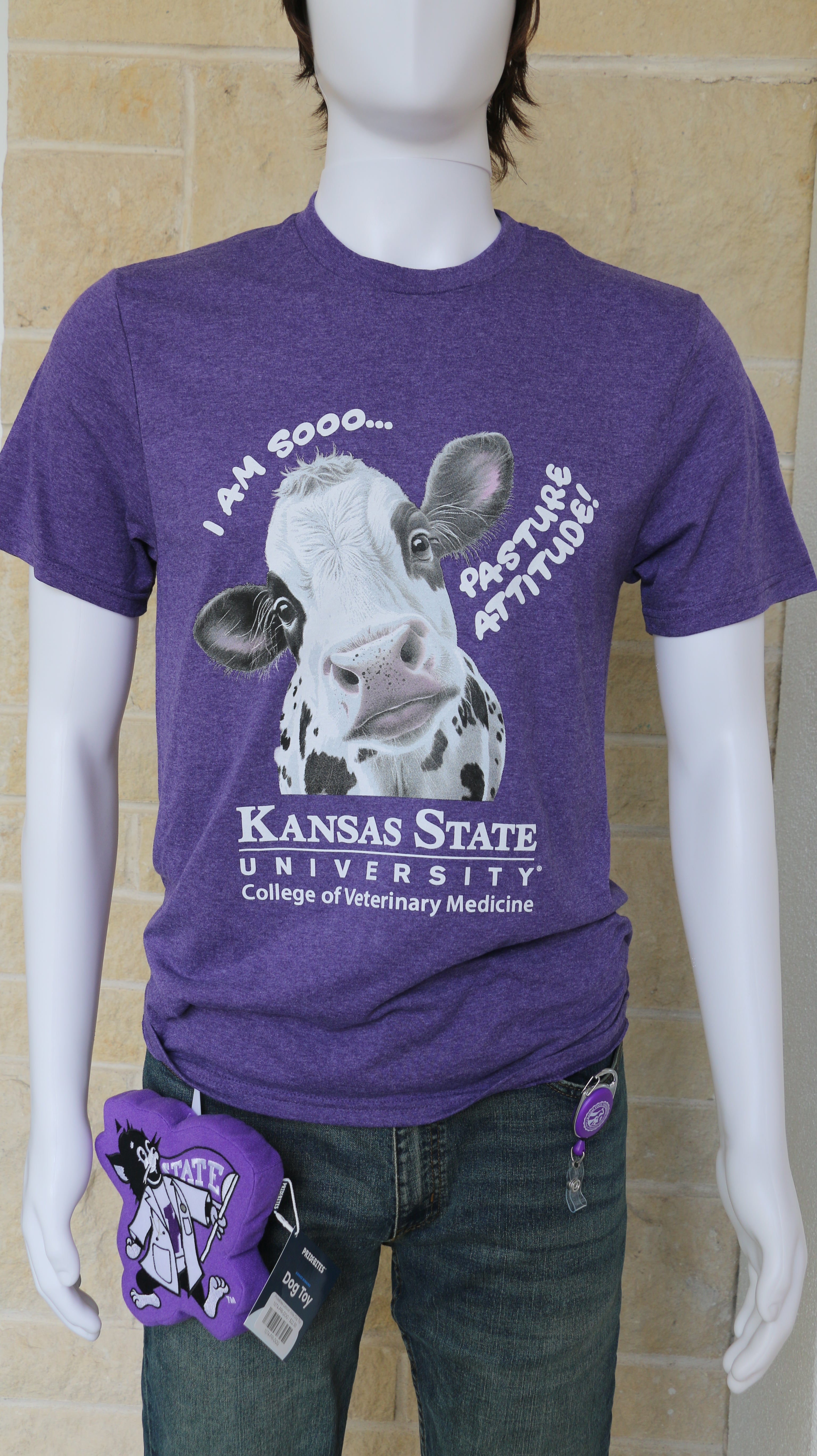 A mannequin wearing a heathered purple Port & Co t-shirt with a graphic of a cow and text that reads "I am sooo... pasture attitude!" with the K-State CVM logo. 