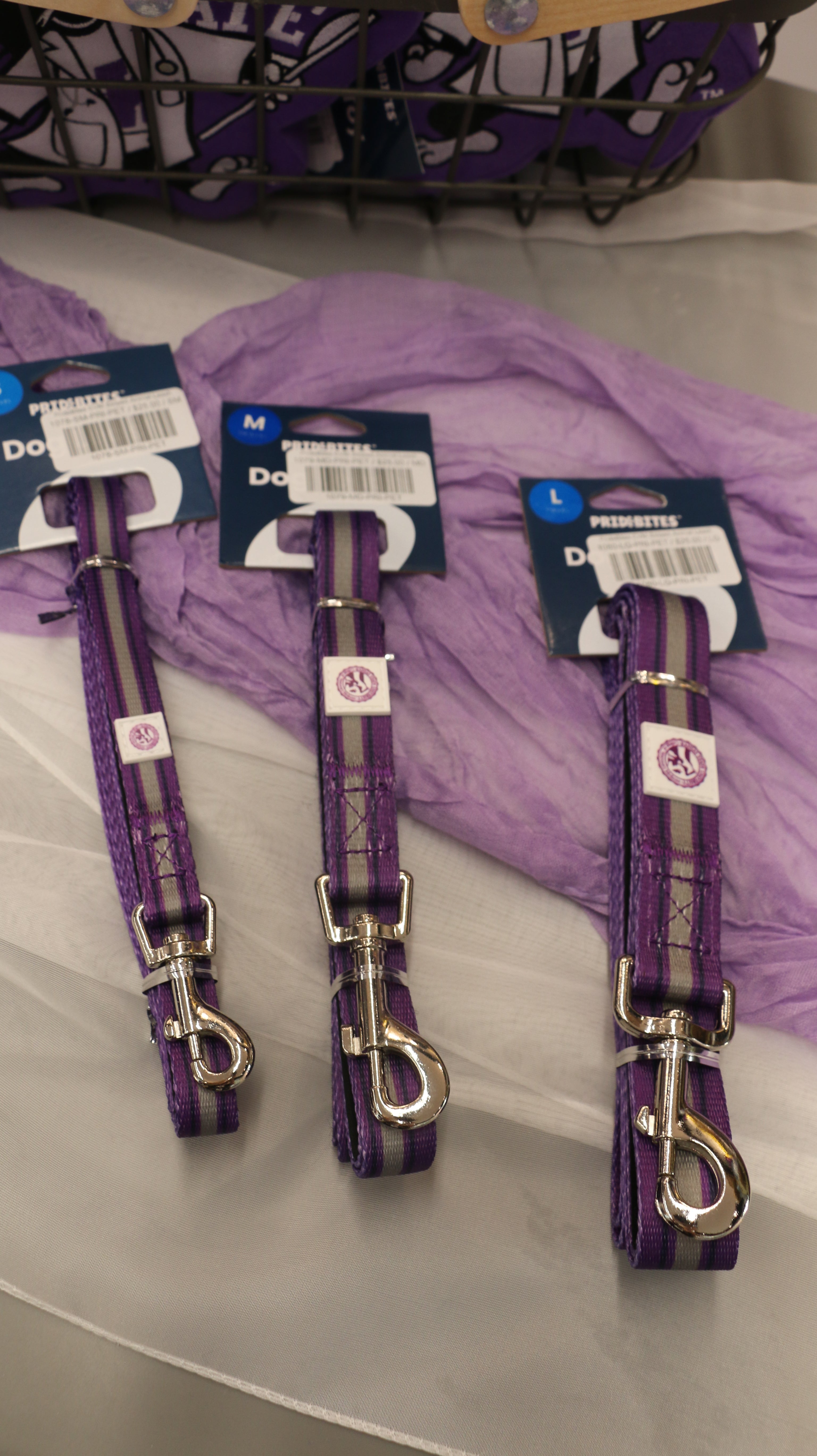 A set of three striped animal leashes in different sizes, featuring a purple and grey color pattern and metal clasps on the end.