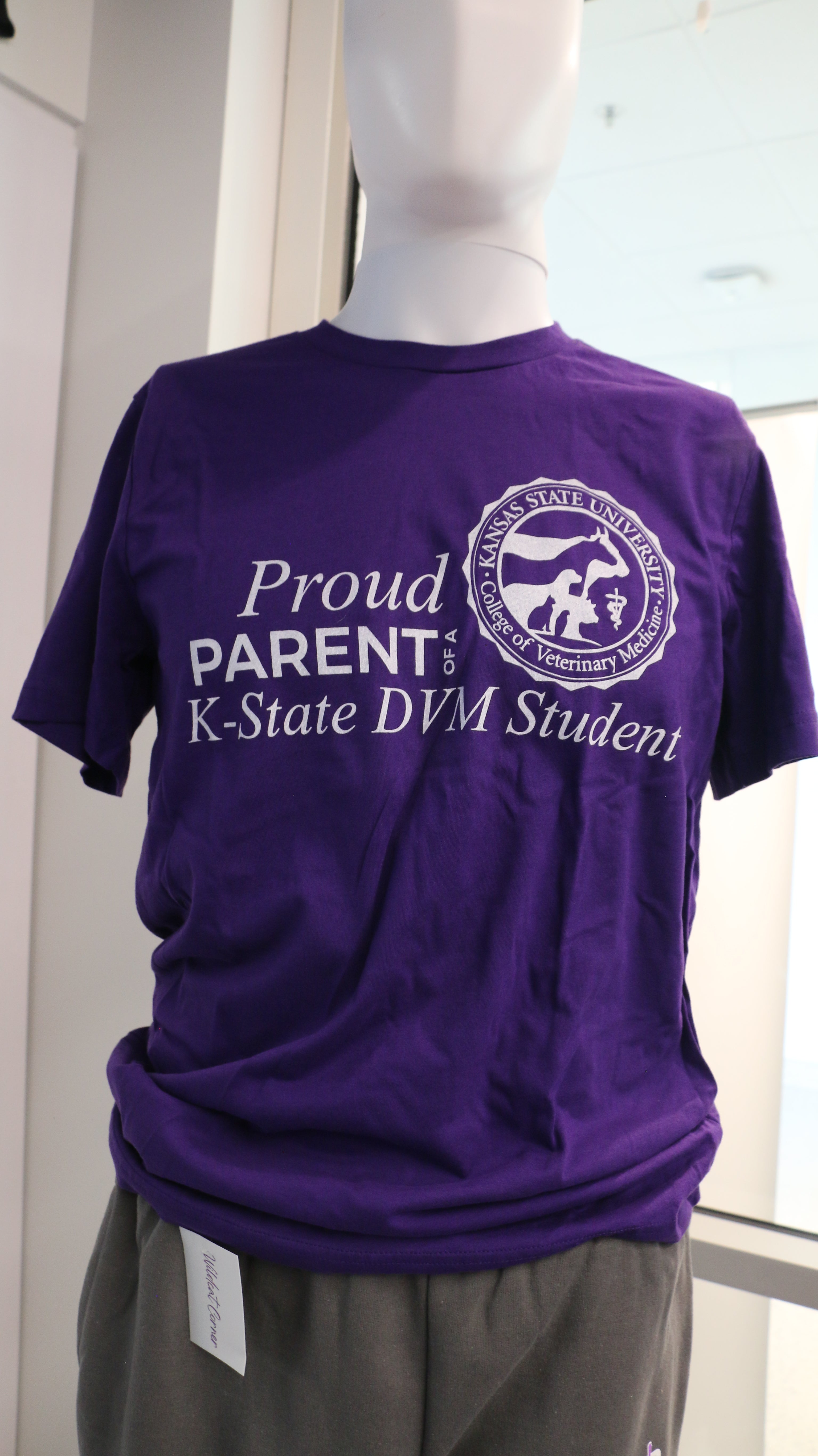 A purple Bella Canvas T-shirt displayed on a mannequin, with 'PROUD PARENT K-STATE DVM STUDENT' printed on the front.