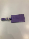 A purple leather luggage tag with a buckled strap and embossed text 'Kansas State University College of Veterinary Medicine'.