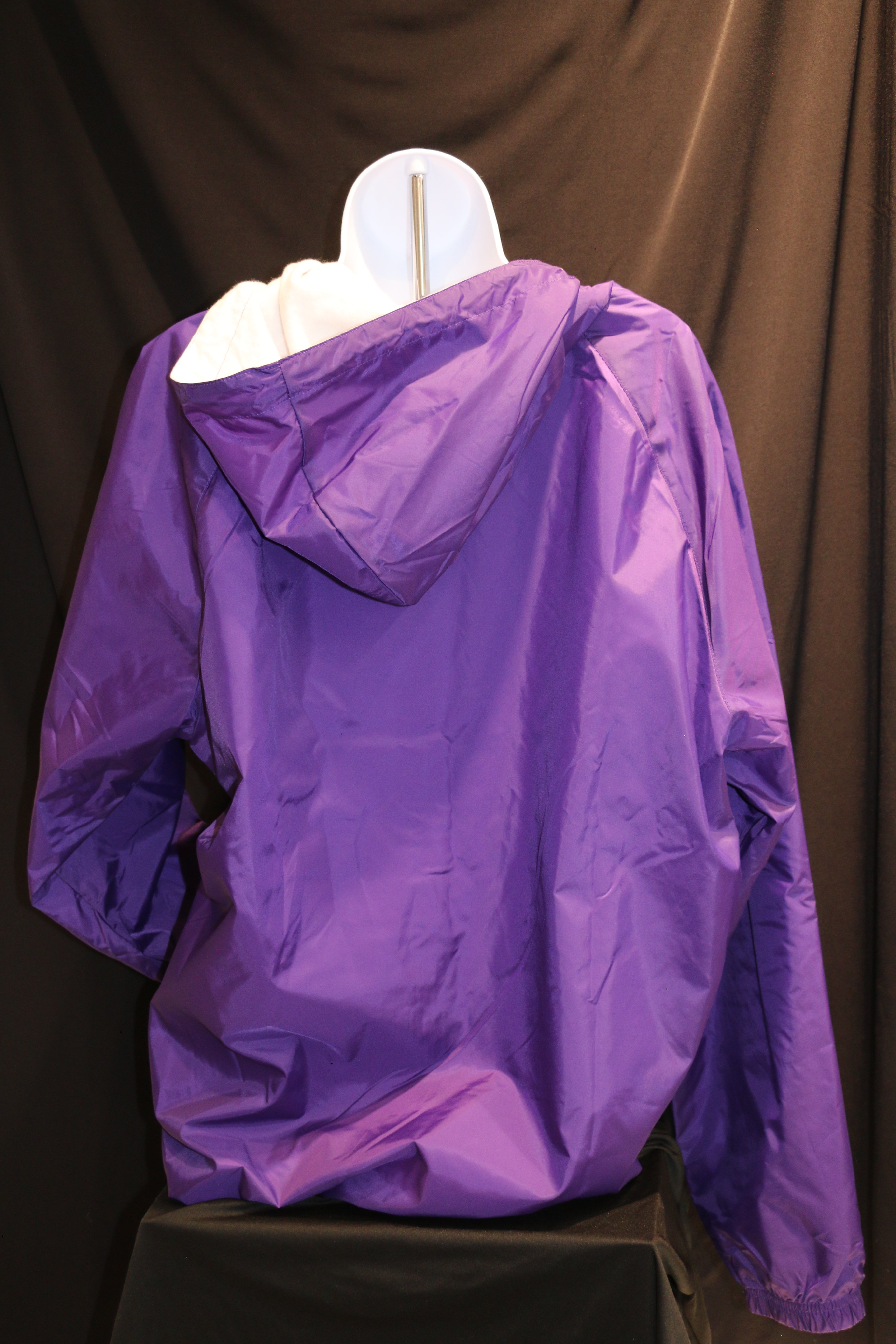A rear view of a purple Charles River rain jacket
