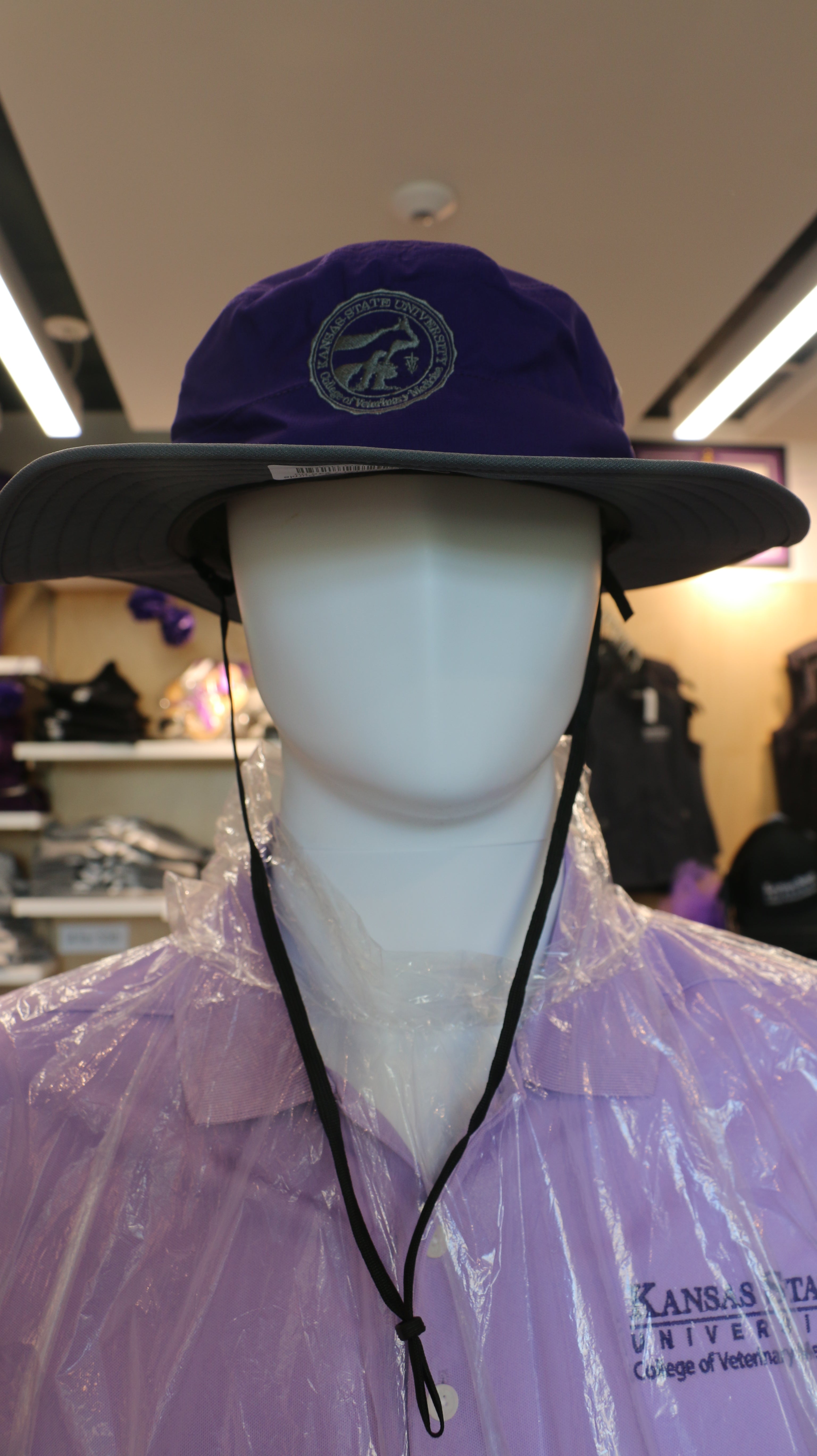 A purple wide brim sun hat on a mannequin with the CVM seal. 