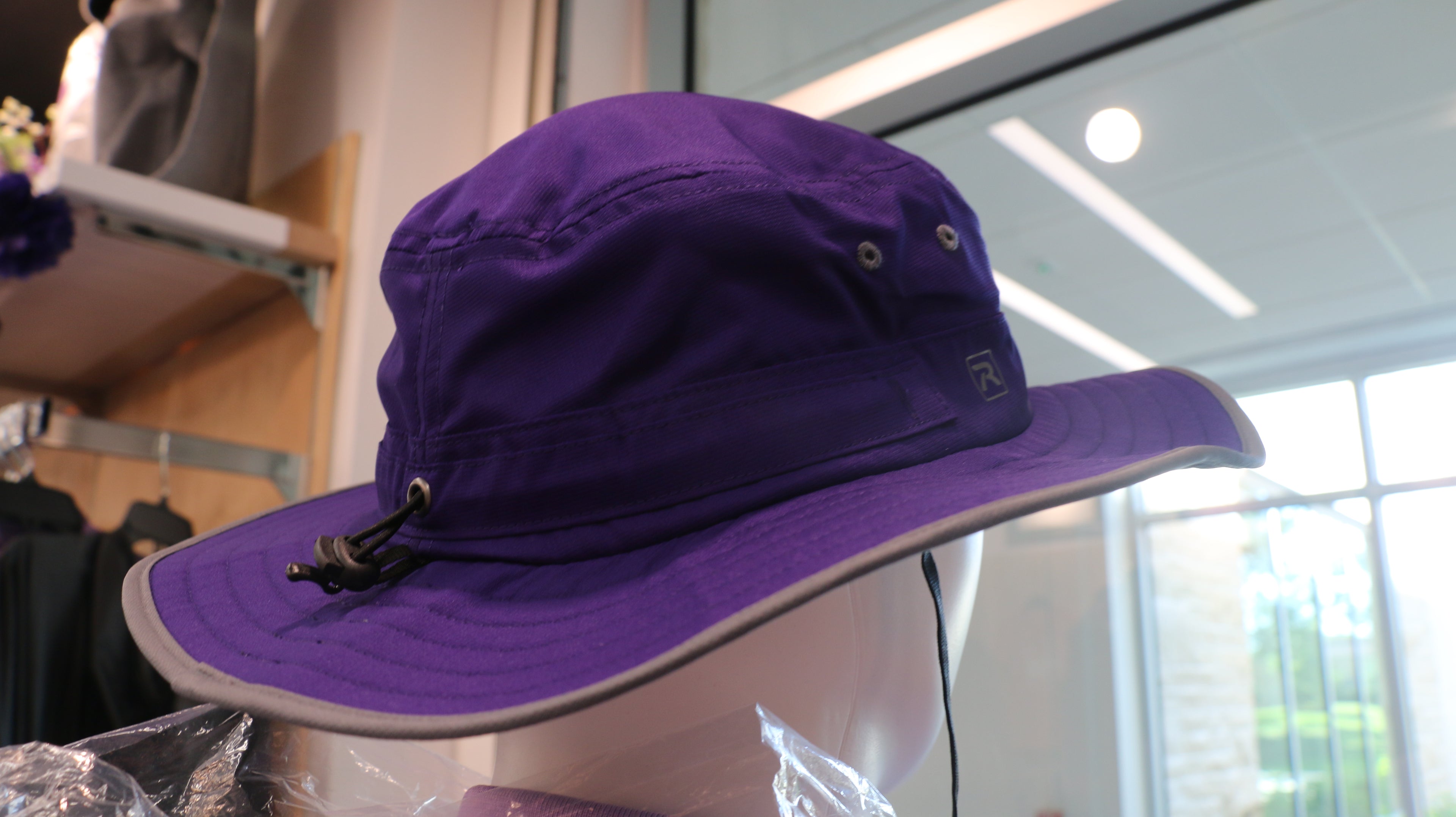 A purple wide brim sun hat on a mannequin.