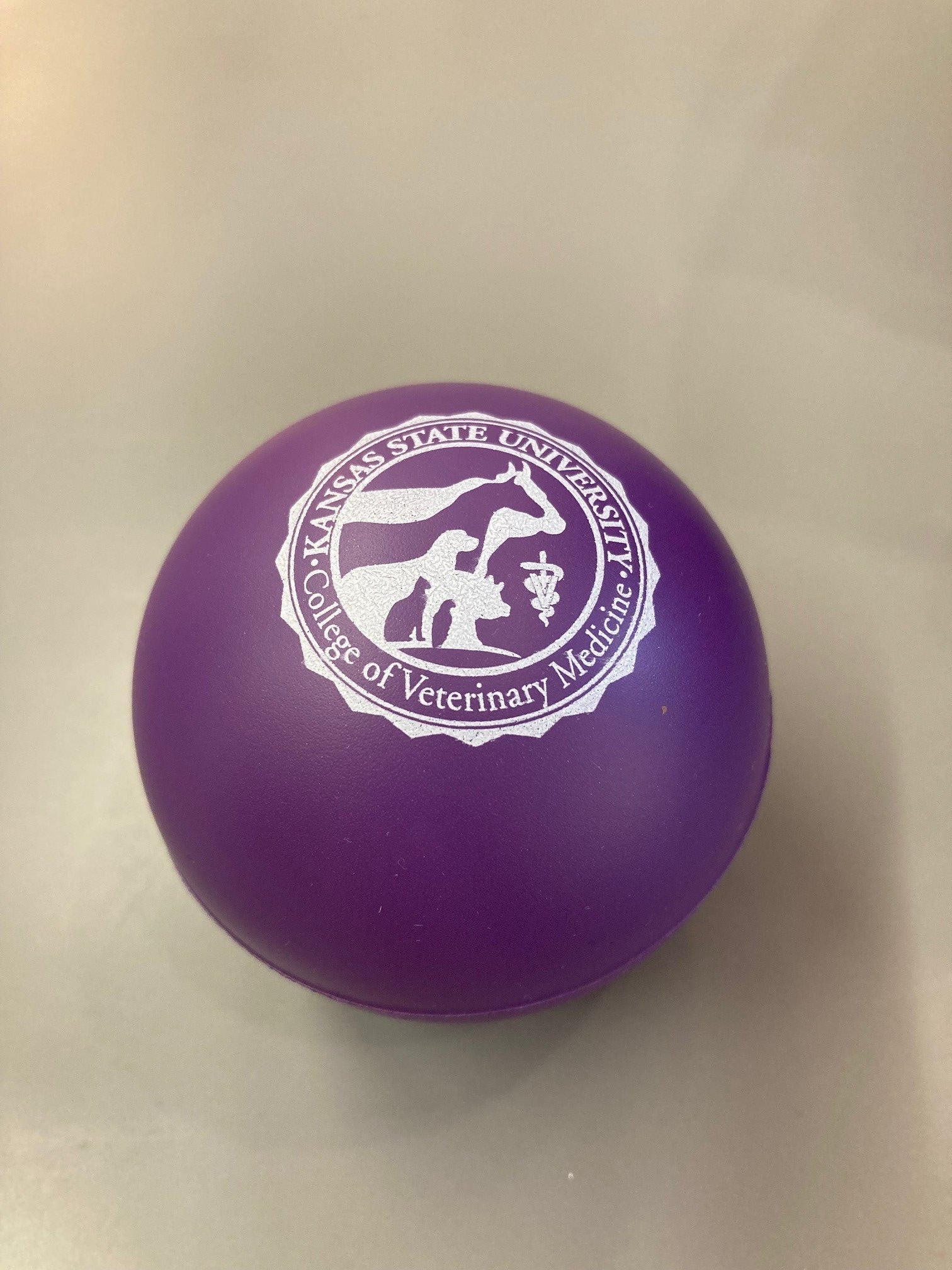 A purple stress ball with the College of Veterinary Medicine seal embossed on it.
