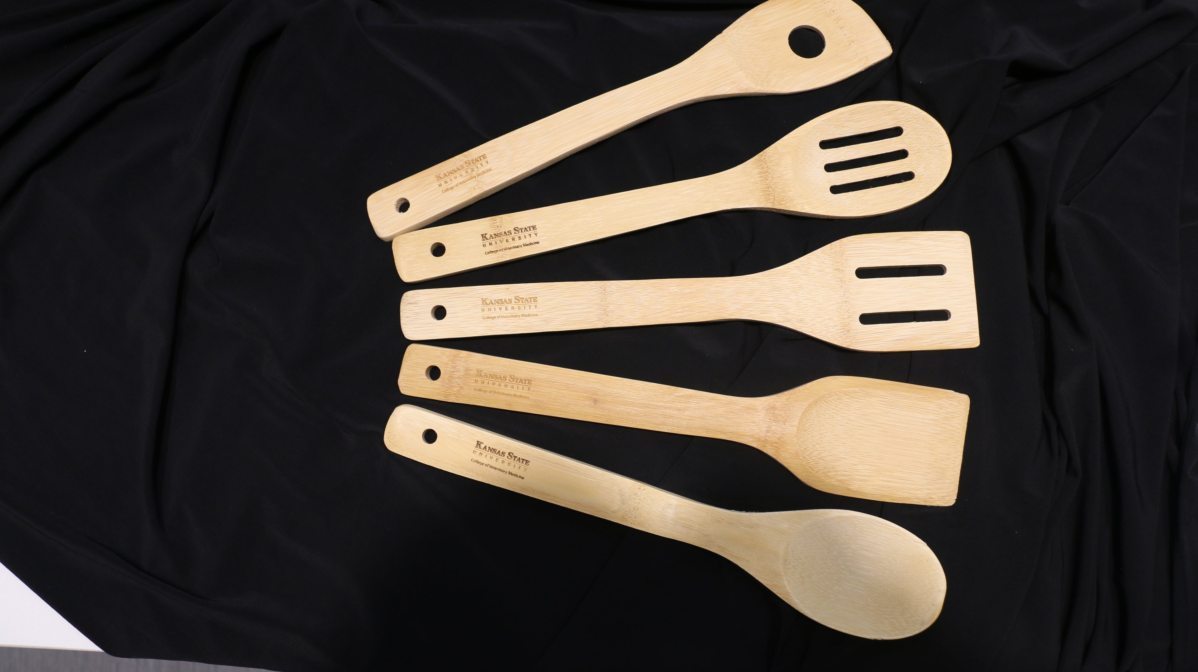 A set of 5 different completely bamboo utensils with Kansas State University College of Veterinary Medicine engraved on the handles. 