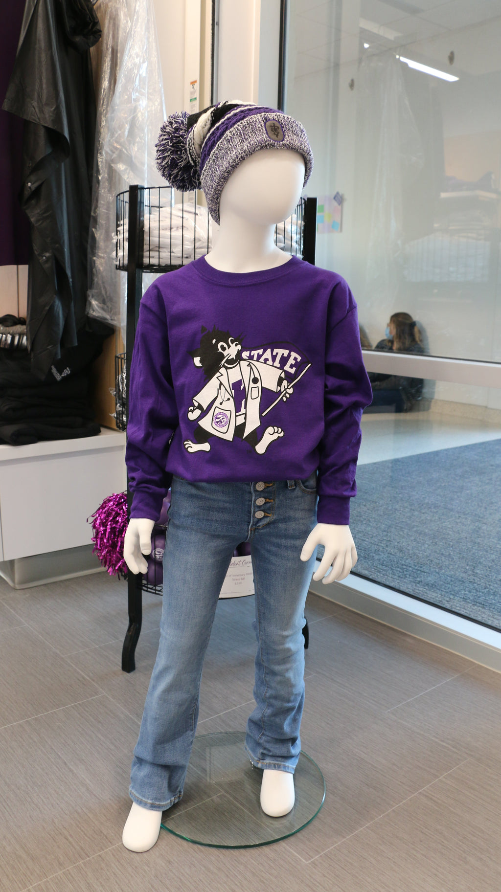 A mannequin displaying a purple youth-sized purple Gildan long sleeve t-shirt with a LabCoat Willie graphic print in the center.